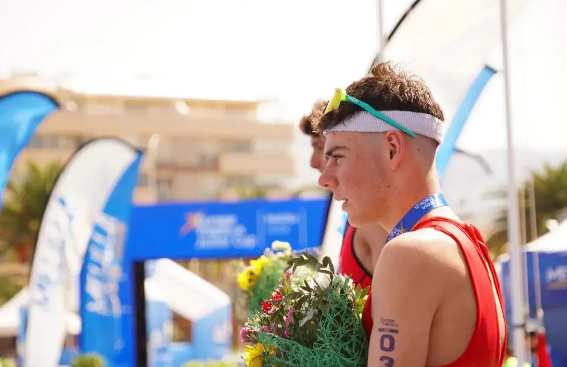 Jarno con medalla y ramo tras la Europe Triathlon Junior Cup de Melilla 2024